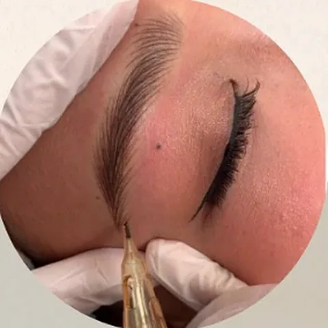 Nano Brows being done with a single fine needle on a digital machine, gloved hands